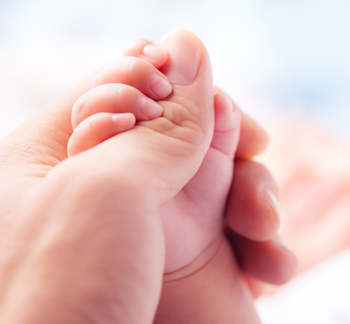 Intimate close-up image capturing a newborn baby's tiny hand firmly grasping an adult finger, symbolizing the profound bond between parent and child.  This image of connection underscores the importance of protecting this precious bond, especially when disrupted by a birth injury.  If your family in Chicago is facing the aftermath of a birth injury, exploring a Birth Injury Lawsuit in Chicago can be a crucial step towards securing justice and support for your child's future.