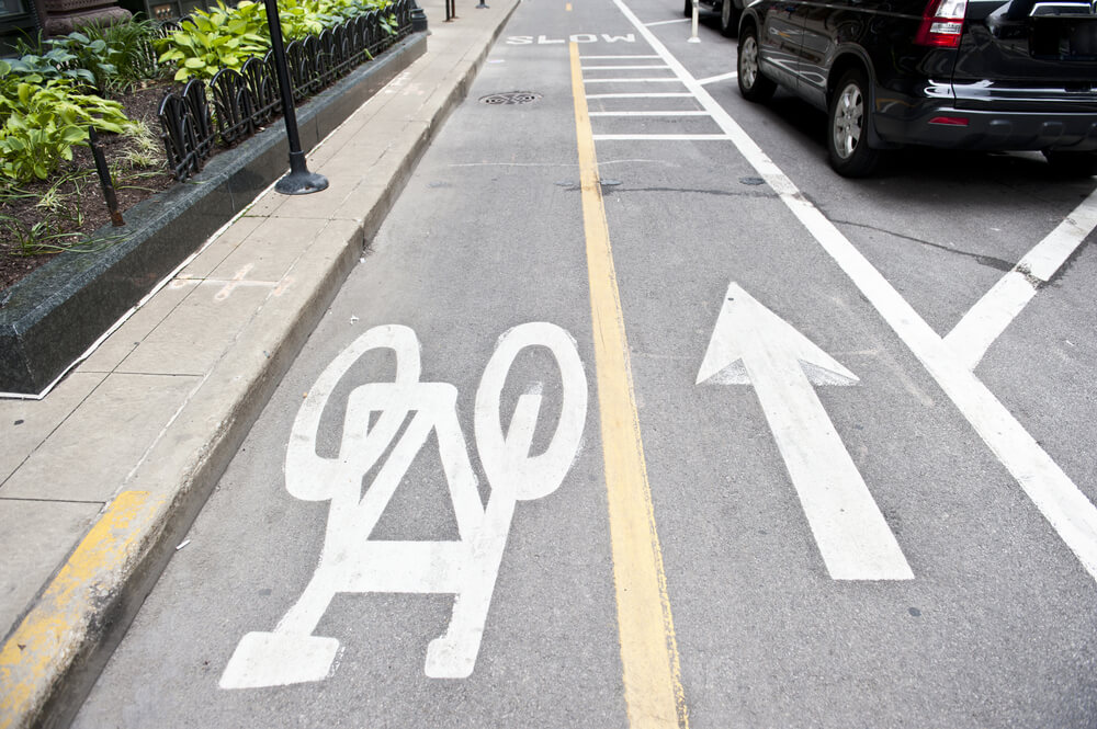 A marked street in Chicago, Illinois pointing distinct lanes for bikes and cars with white marker.